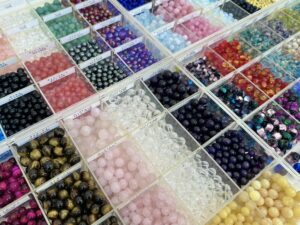 ブレスレット作りに使用する、ローズクォーツやタイガーアイなど多種多様な天然石ビーズが並ぶロックハート城のショップ内