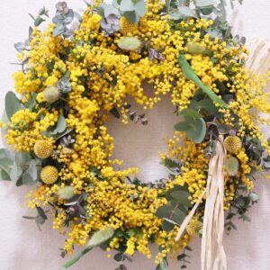 春の訪れを感じさせる、鮮やかな黄色いミモザの花とユーカリをあしらった手作りのフラワーリース