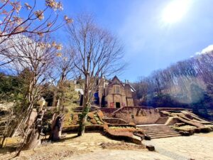 青空と太陽の光が降り注ぐ、群馬県高山村のロックハート城の全景。ドレス体験やフォトウェディングの舞台となる英国移築の本物の古城と石造りの階段。
