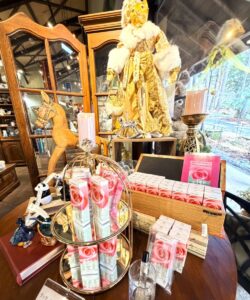 ロックハート城のギャラリーショップ。バラのデザインの香水瓶が並んだ、クラシカルで華やかなディスプレイと、それを彩る猫の人形やチェス駒。