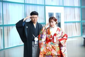 本物の中世ヨーロッパの古城「ロックハート城」を舞台にした、和装の結婚式。歴史ある石造りの空間で、鮮やかな赤の色打掛を纏った新婦と紋付羽織袴の新郎が、特別な演出を行う非日常的な光景。