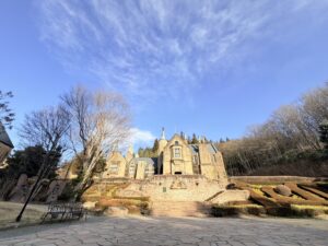 鮮やかな青空と太陽の下、階段の先に見える重厚な石造りのロックハート城。お庭を一緒にお散歩できる、ペットフレンドリーなお castle の全景。