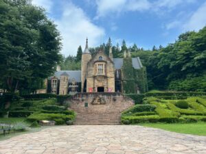 群馬県高山村のロックハート城。青空と緑に囲まれた本物のスコットランド古城を正面から撮影した風景。