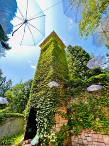 ロックハート城のツタに覆われた塔を見上げる夏の風景。青空にラベンダーカラーのアンブレラスカイが広がるフォトスポット。