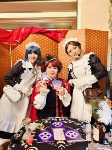 ロックハート城で開催されたローザ・ヴァインの占い体験イベントで、宮廷占い師とメイドが記念撮影をする様子